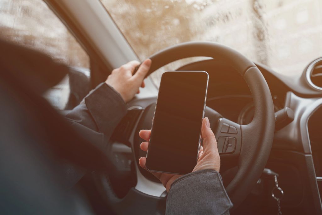 Person Holding Phone While Driving